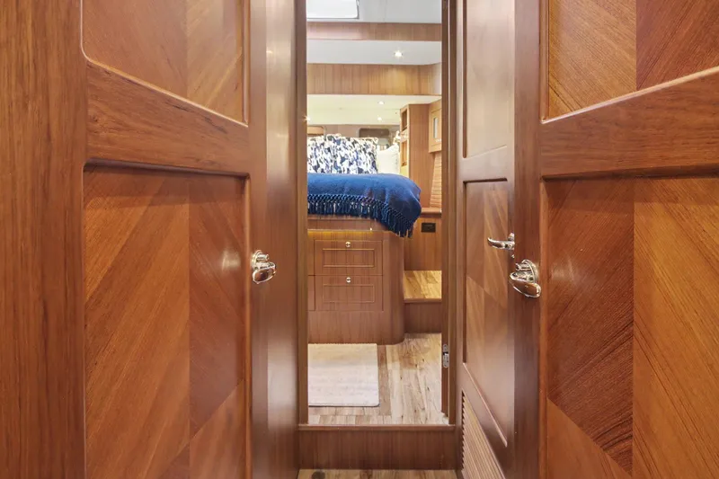 Slide: The Image of Interior of 2022 North Pacific 45 Pilothouse yacht with wooden doors and cozy bedroom. - 25