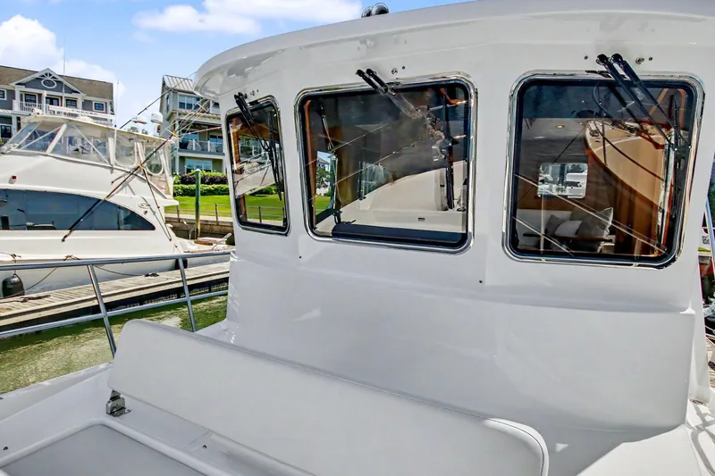 Slide: The Image of 2022 North Pacific 45 Pilothouse yacht docked at marina, showcasing sleek design and windows. - 35