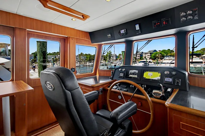 Slide: The Image of Pilothouse interior of 2022 North Pacific 45, featuring navigation controls and panoramic windows. - 2