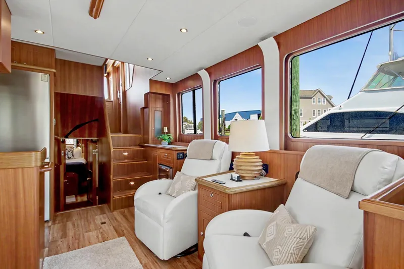 Slide: The Image of Luxurious interior of 2022 North Pacific 45 Pilothouse yacht with plush seating and wood finishes. - 9