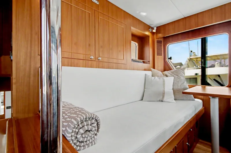 Slide: The Image of Interior of 2022 North Pacific 45 Pilothouse with cozy seating and wooden cabinetry. - 19