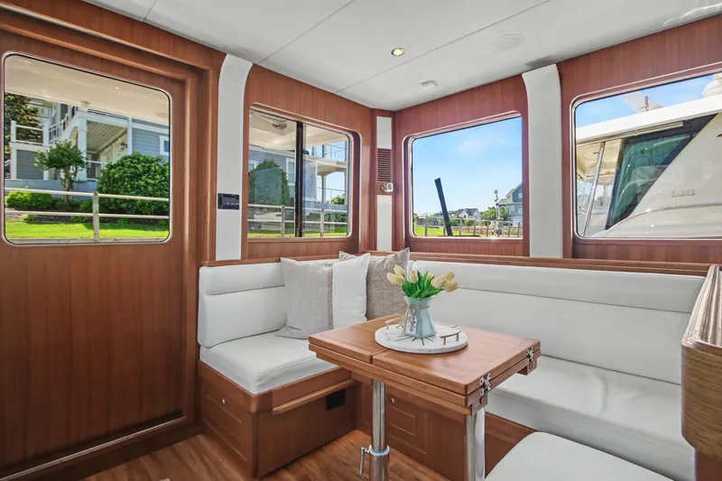 Slide: The Image of Interior of 2022 North Pacific 45 Pilothouse with elegant seating and wooden accents. - 10