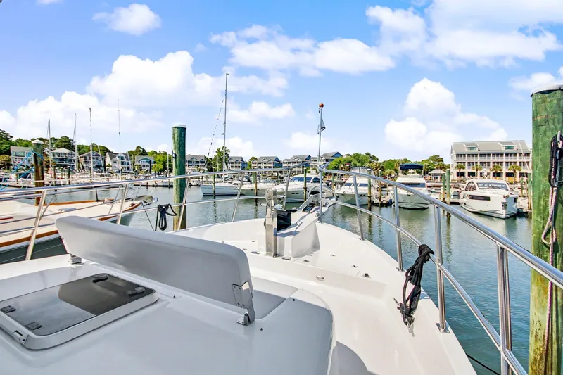 Slide: The Image of 2022 North Pacific 45 Pilothouse yacht docked in a scenic marina. - 33