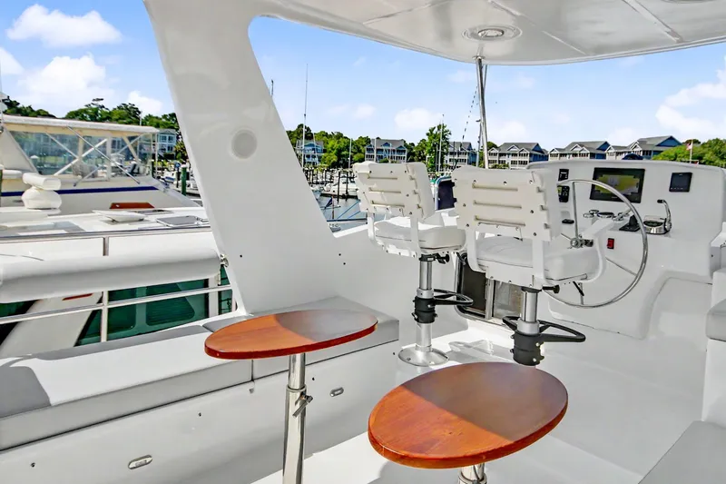 Slide: The Image of Pilothouse of 2022 North Pacific 45 yacht with helm chairs and wooden tables. - 42