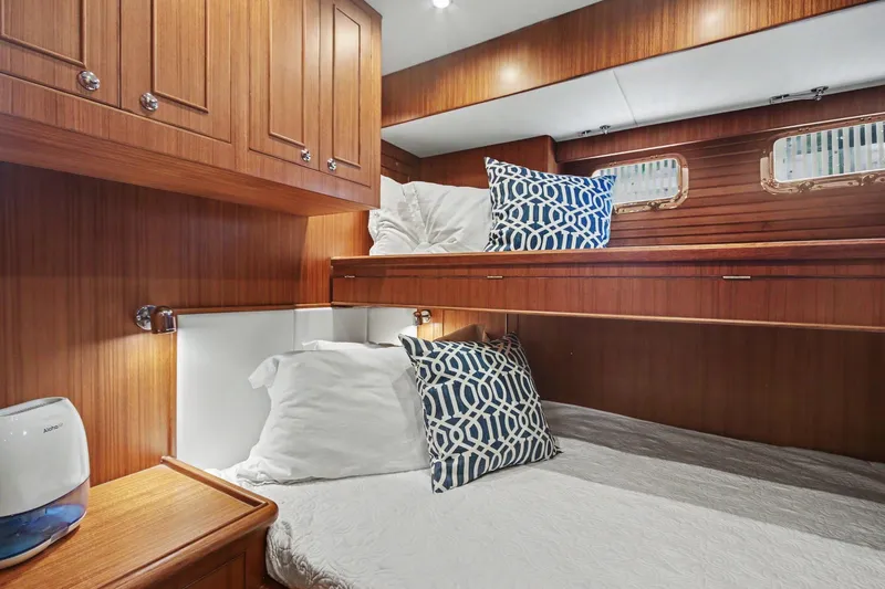 Slide: The Image of Cozy cabin interior of 2022 North Pacific 45 Pilothouse with wooden finish and patterned pillows. - 21