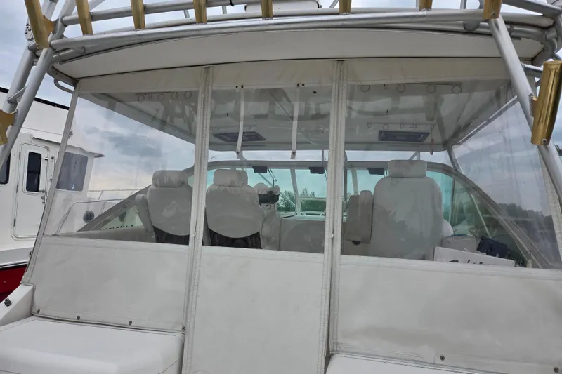 Slide: The Image of 1999 Cabo 35 Express boat interior with seating and clear enclosure. - 12