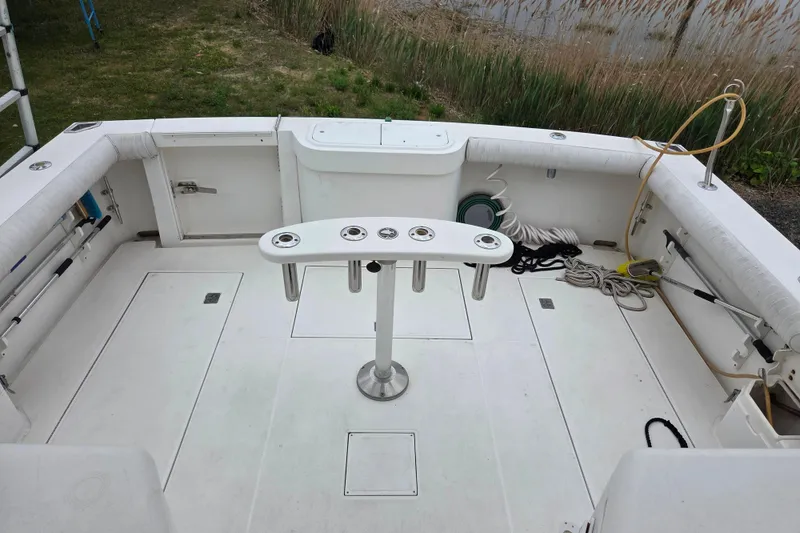 Slide: The Image of 1999 Cabo 35 Express boat deck with fishing rod holders and storage compartments. - 16