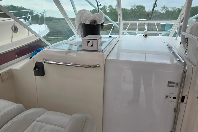 Slide: The Image of Interior view of a 1999 Cabo 35 Express boat cockpit with seating and storage. - 19