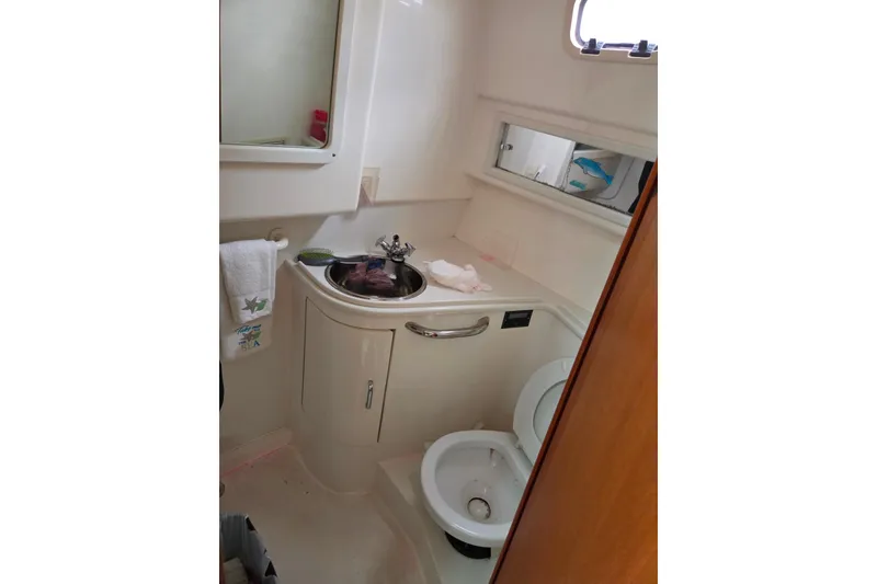 Slide: The Image of Bathroom interior of a 1999 Cabo 35 Express boat with sink and toilet. - 27