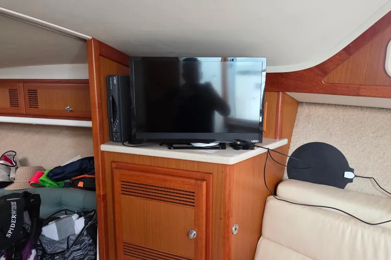 Slide: The Image of Interior of 1999 Cabo 35 Express boat with TV and wooden cabinetry. - 29