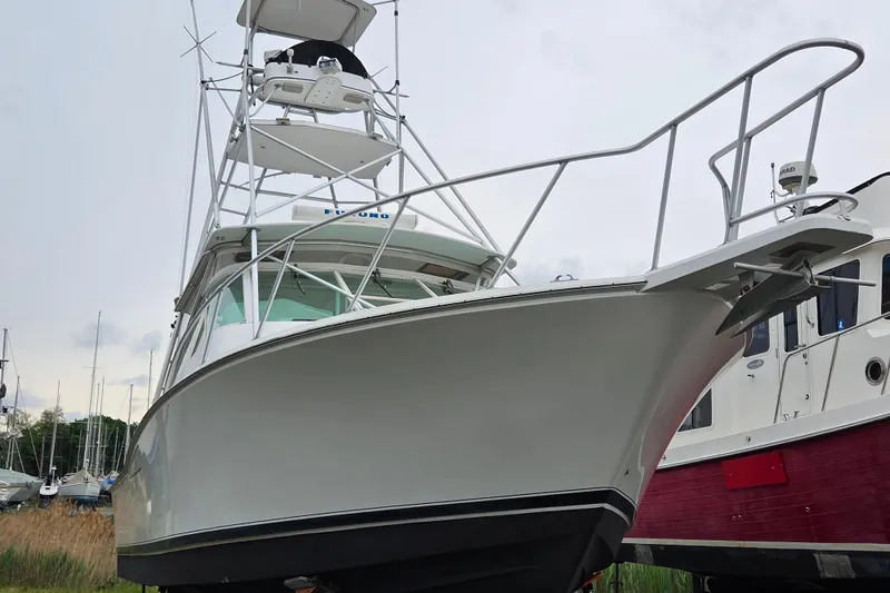 Slide: The Image of 1999 Cabo 35 Express boat with tower, docked alongside other vessels. - 3