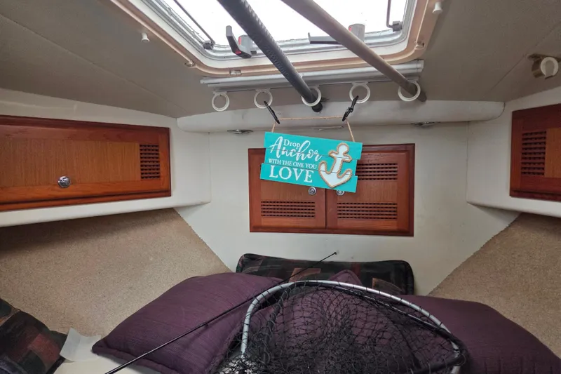 Slide: The Image of Interior of a 1999 Cabo 35 Express boat with cozy decor and fishing net. - 31