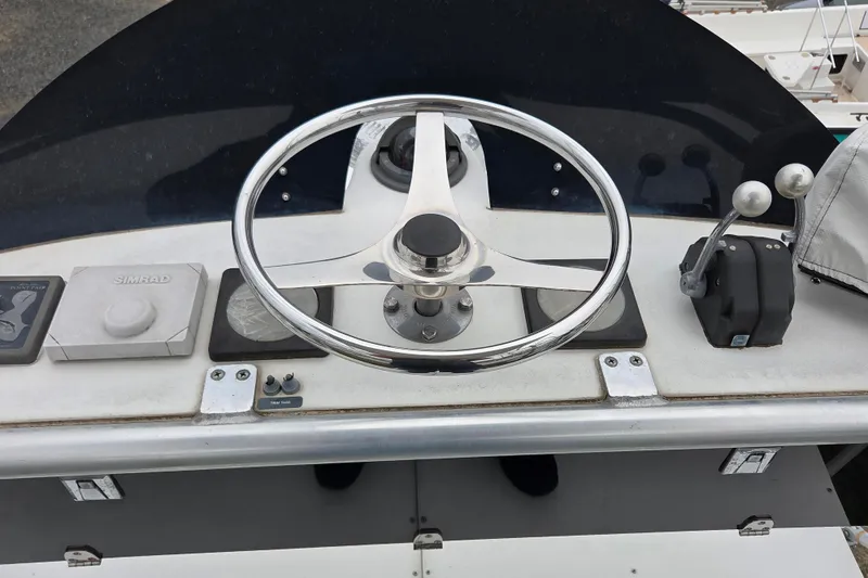 Slide: The Image of Steering wheel and controls of a 1999 Cabo 35 Express boat. - 39