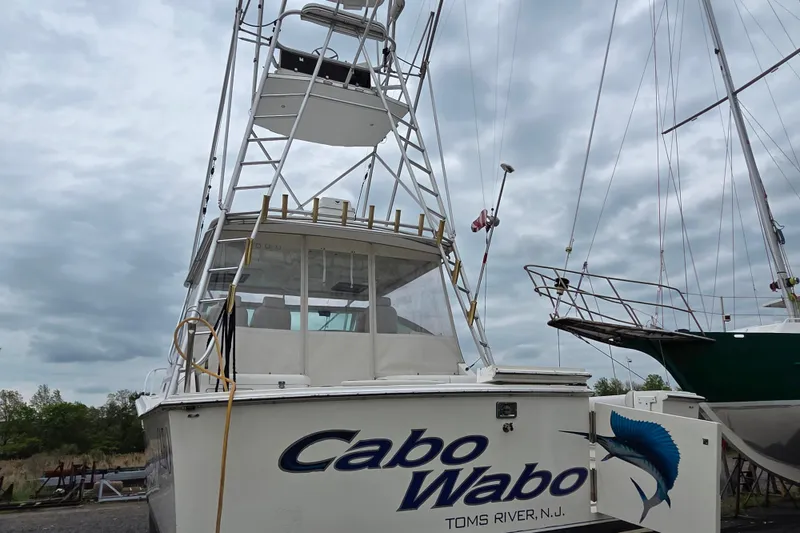 Slide: The Image of 1999 Cabo 35 Express boat with tower, docked in Toms River, NJ, under cloudy skies. - 4