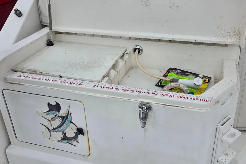 Slide: The Image of 1999 Cabo 35 Express boat storage compartment with fishing gear and marina details. - 8