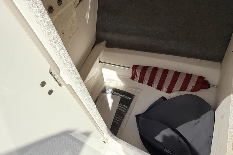 Slide: The Image of Storage compartment in a 2016 Chaparral 246 SSi boat with umbrella and manual. - 15