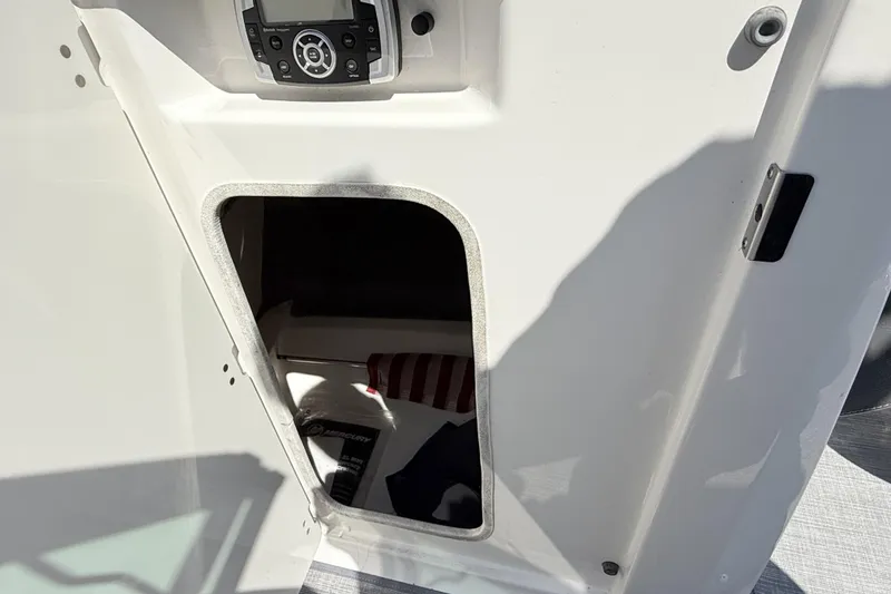 Slide: The Image of 2016 Chaparral 246 SSi boat storage compartment with control panel above. - 27