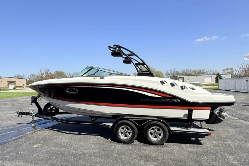 Slide: The Image of 2016 Chaparral 246 SSi boat on trailer, parked outdoors under clear blue sky. - 3