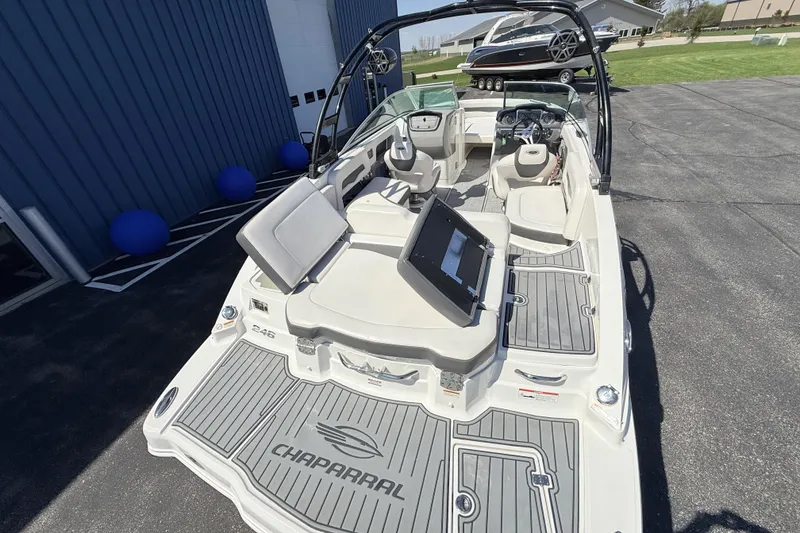 Slide: The Image of 2016 Chaparral 246 SSi boat with spacious seating and modern dashboard, docked outdoors. - 9