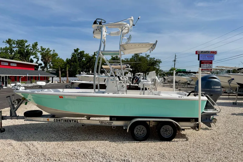 The Image of 2010 NauticStar 2110 Nautic Bay boat on trailer at marina, clear sky background. - 0
