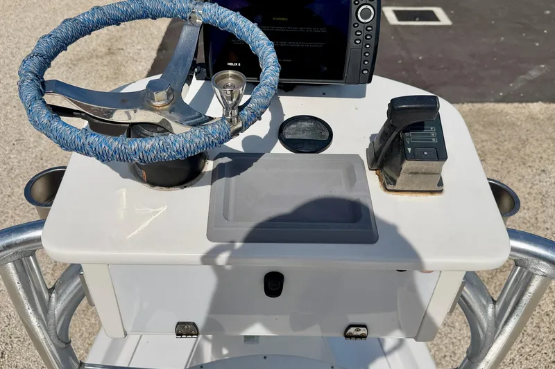 Slide: The Image of Steering console of 2010 NauticStar 2110 Nautic Bay boat with blue-wrapped wheel and controls. - 18