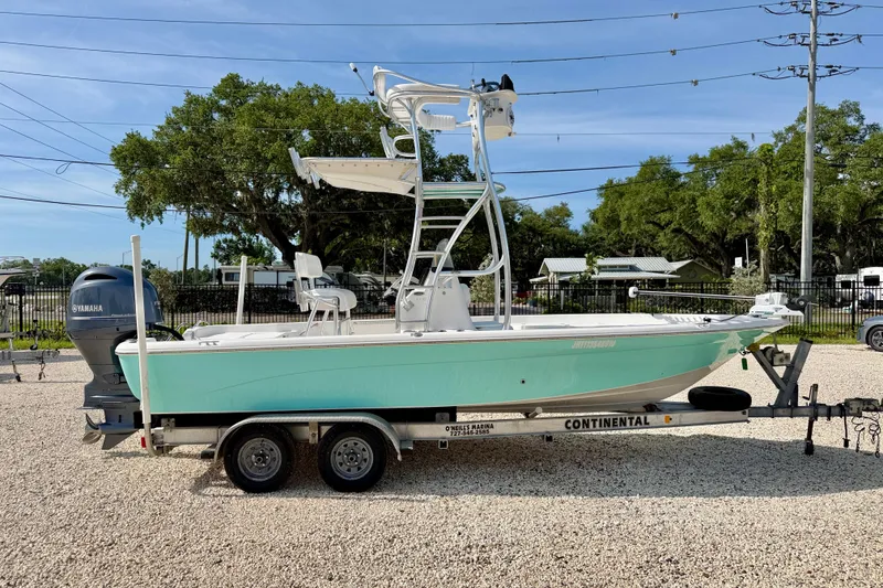 Slide: The Image of 2010 NauticStar 2110 Nautic Bay boat on trailer, parked outdoors with trees in background. - 4