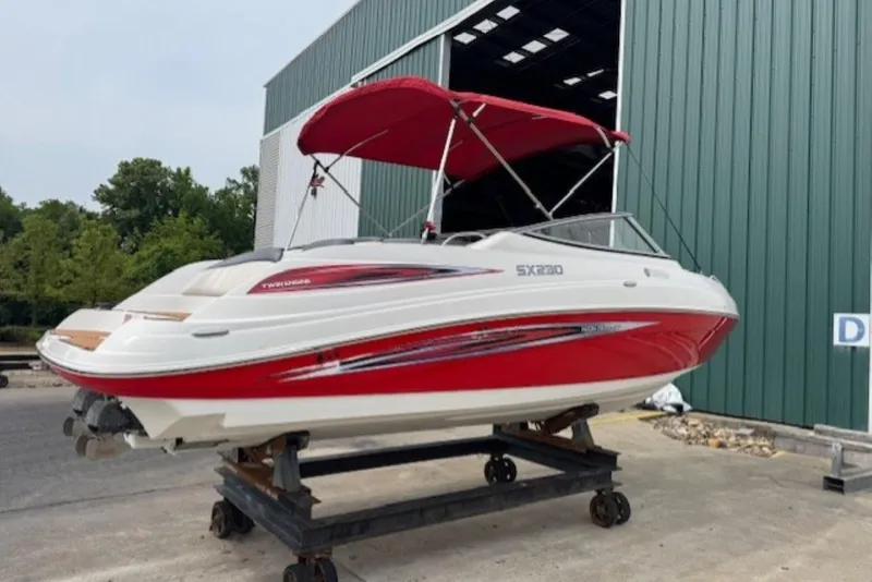 Slide: The Image of 2008 Yamaha Boats SX230 HO with red accents, docked near a green building. - 4