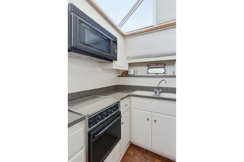 Slide: The Image of Compact kitchen in 1998 Carver 445 Aft Cabin Motor Yacht with microwave and stove. - 27