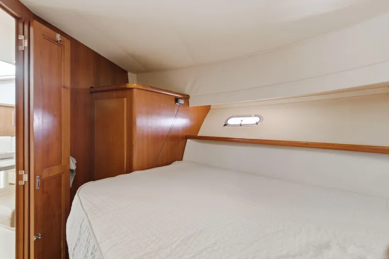 Slide: The Image of 1998 Carver 445 Aft Cabin Motor Yacht bedroom with wood paneling and cozy bed. - 30