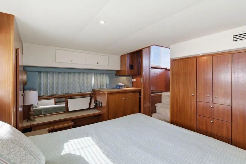 Slide: The Image of Luxurious 1998 Carver 445 Aft Cabin Motor Yacht bedroom with wood cabinetry and elegant decor. - 34