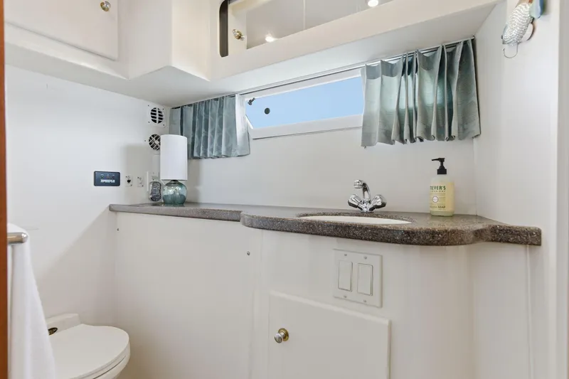 Slide: The Image of 1998 Carver 445 Aft Cabin Motor Yacht bathroom with sink, toilet, and window. - 37
