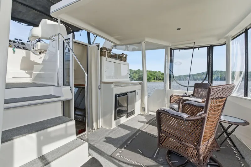 Slide: The Image of 1998 Carver 445 Aft Cabin Motor Yacht interior with wicker chairs and scenic water view. - 8
