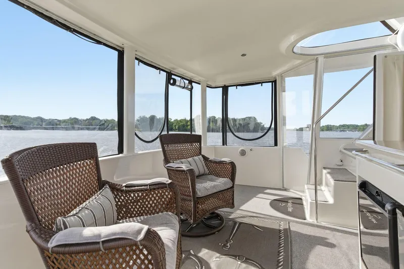 Slide: The Image of 1998 Carver 445 Aft Cabin Motor Yacht interior with wicker chairs and scenic water view. - 9
