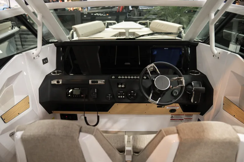 Slide: The Image of Interior view of 2026 Axopar 29 Sun-Top boat cockpit with steering wheel and controls. - 11