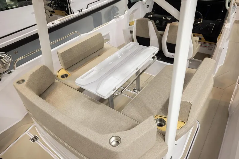 Slide: The Image of 2026 Axopar 29 Sun-Top boat interior with beige seating and a central table. - 8