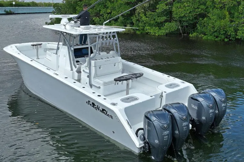 Slide: The Image of Manufacturer Provided Image: 2025 SeaHunter 38 CTS boat with triple outboard engines on a calm waterway. - 2