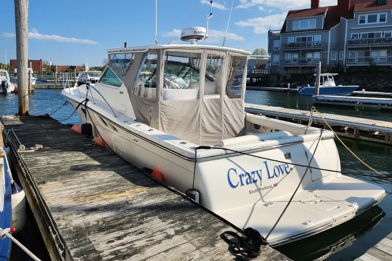 Slide: The Image of 1998 Tiara Yachts 3500 Open docked, named "Crazy Love," in a marina setting. - 1
