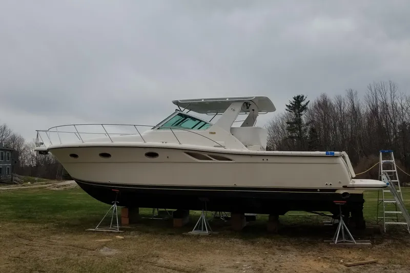 Slide: The Image of 1998 Tiara Yachts 3500 Open on stands, overcast sky, grassy area, trees in background. - 10