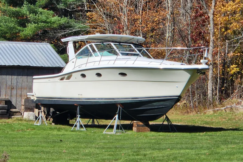 Slide: The Image of 1998 Tiara Yachts 3500 Open on stands, surrounded by autumn trees and a shed. - 13