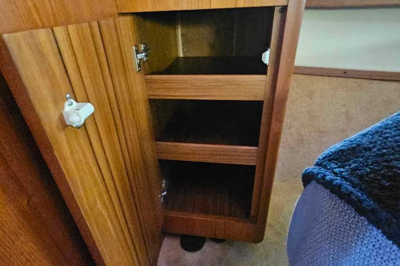 Slide: The Image of Wooden cabinet with open door and shelves inside a 1998 Tiara Yachts 3500 Open. - 27