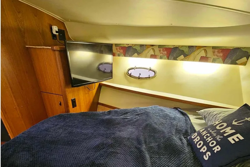 Slide: The Image of Cozy cabin interior of 1998 Tiara Yachts 3500 Open with bed, TV, and nautical decor. - 28