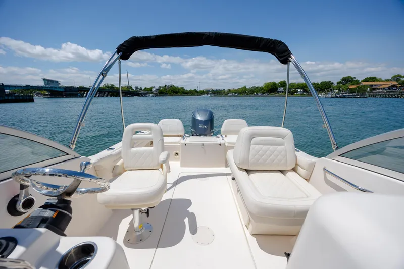 Slide: The Image of 2019 Grady-White Freedom 215 boat interior with seating and steering wheel on a sunny day. - 11