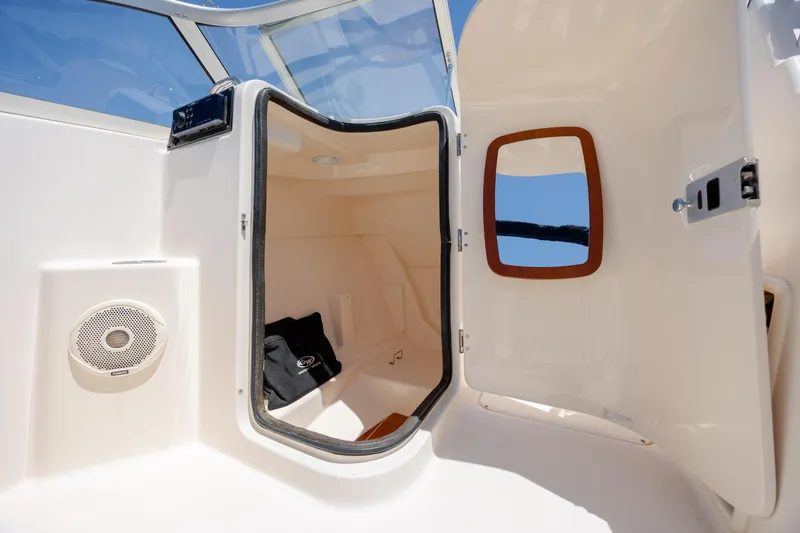 Slide: The Image of 2019 Grady-White Freedom 215 boat cabin interior with open door and speaker. - 14