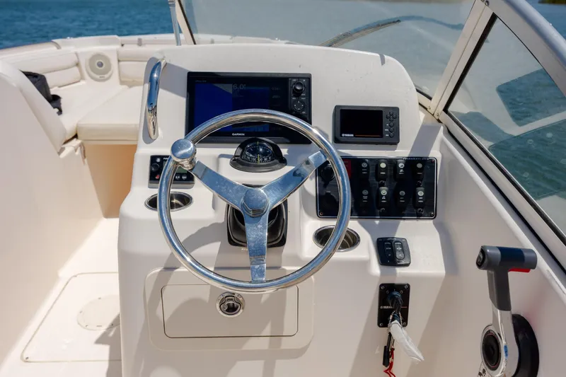 Slide: The Image of Steering console of 2019 Grady-White Freedom 215 boat with navigation controls. - 18