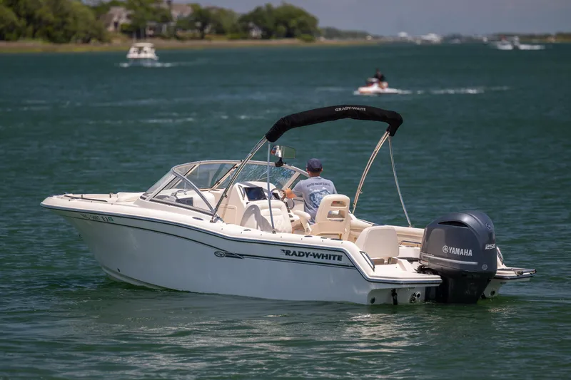 Slide: The Image of 2019 Grady-White Freedom 215 boat cruising on a serene lake with Yamaha engine. - 2
