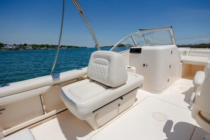 Slide: The Image of 2019 Grady-White Freedom 215 boat interior with white seating and open water view. - 22