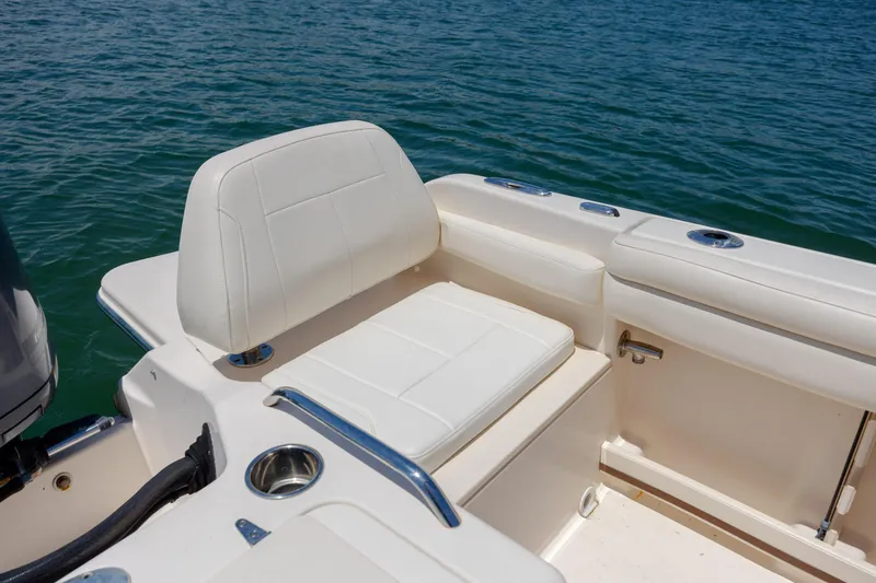 Slide: The Image of 2019 Grady-White Freedom 215 boat interior with white seating, on calm blue water. - 24