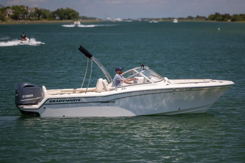 Slide: The Image of 2019 Grady-White Freedom 215 boat cruising on a serene lake with Yamaha engine. - 4