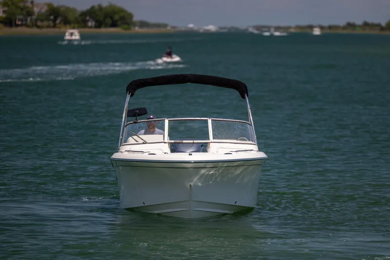 Slide: The Image of 2019 Grady-White Freedom 215 boat cruising on a serene waterway. - 6