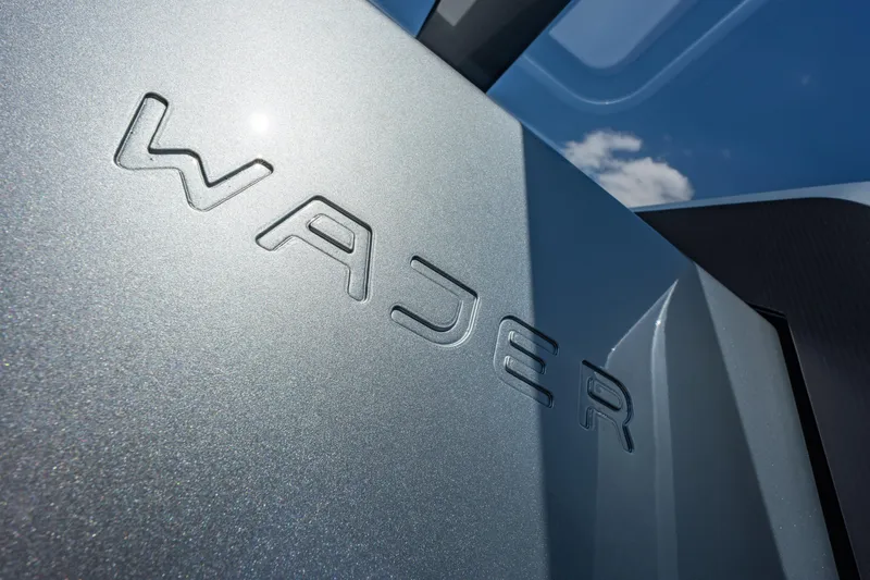 Slide: The Image of Close-up of Wajer 77 yacht logo on metallic surface under blue sky. - 34